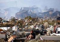 2011-ben egy nő a földrengés utáni romok között ül Japánban.